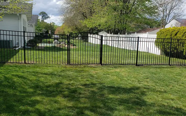 Black aluminum fence with an arched walk gate